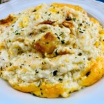 A white plate of Hashbrown with melted cheese.