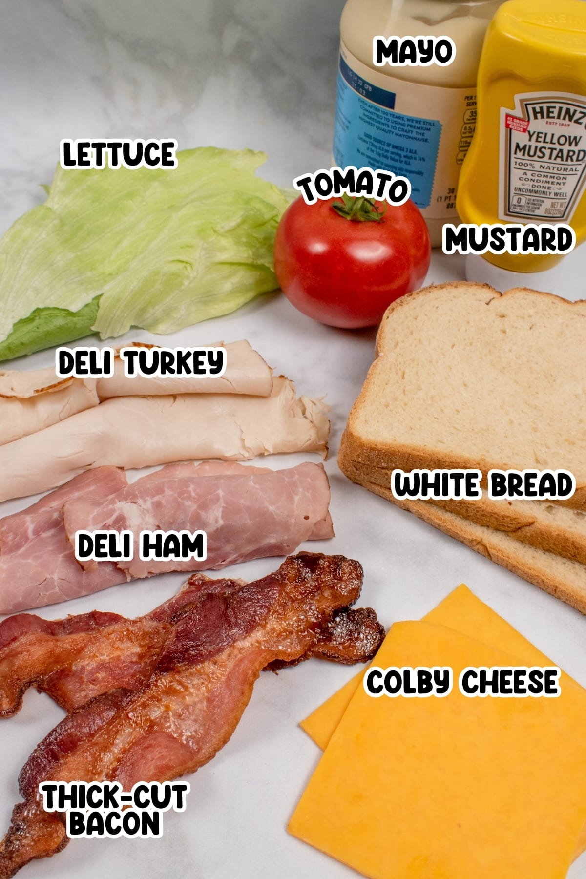 Ingredients for Club Sandwich sitting on a white countertop.