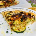White plate with Italian Sausage and Zucchini Galette With Tomatoes and Ricotta.