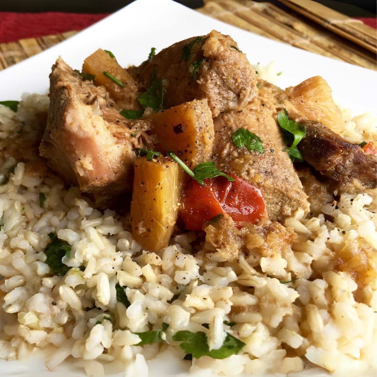 Pineapple Pork Roast in a bed of rice with cilantro on top.