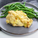 Swiss chicken on a plate with green beans on the side.