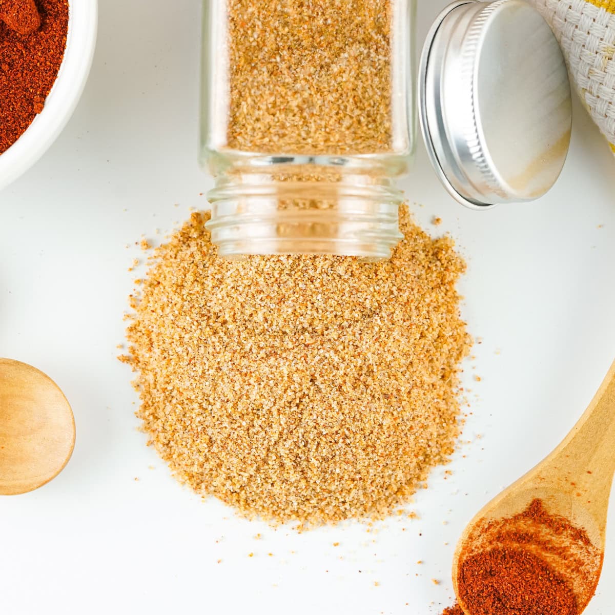 Spilled spice seasoning mixture on a white countertop.