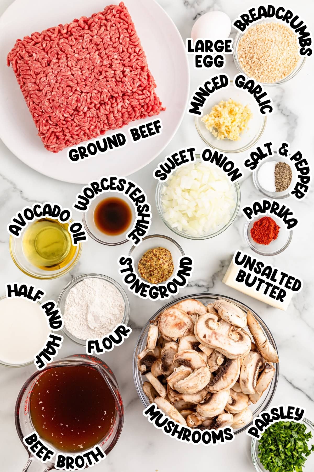 Ingredients for hamburger steak sitting on a marbled countertop.