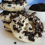 Oreo donut leaning on the other donuts.