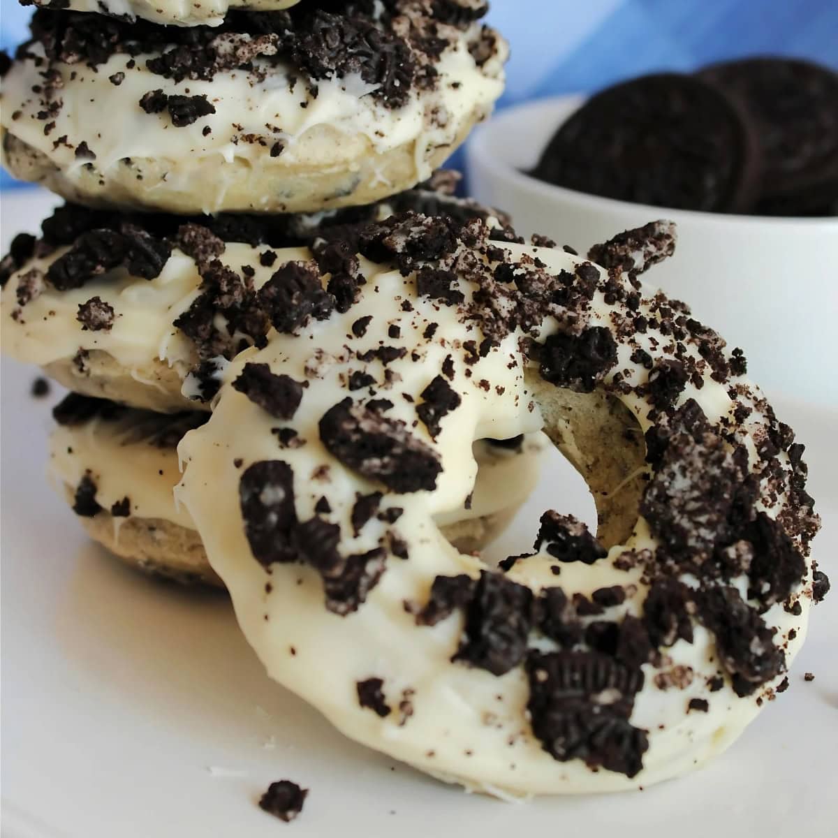 Oreo donut leaning on the other donuts.
