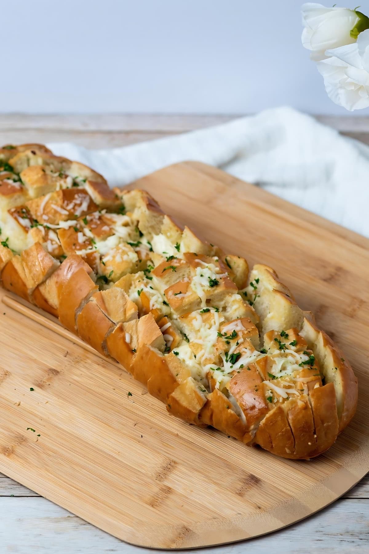 A wooden board with garlic bread.