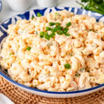 Macaroni Hawaiian Salad on a bue plate topped with chopped green onions.