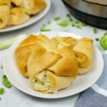 A plate of Chicken crescent rolls sitting on a white countertop.