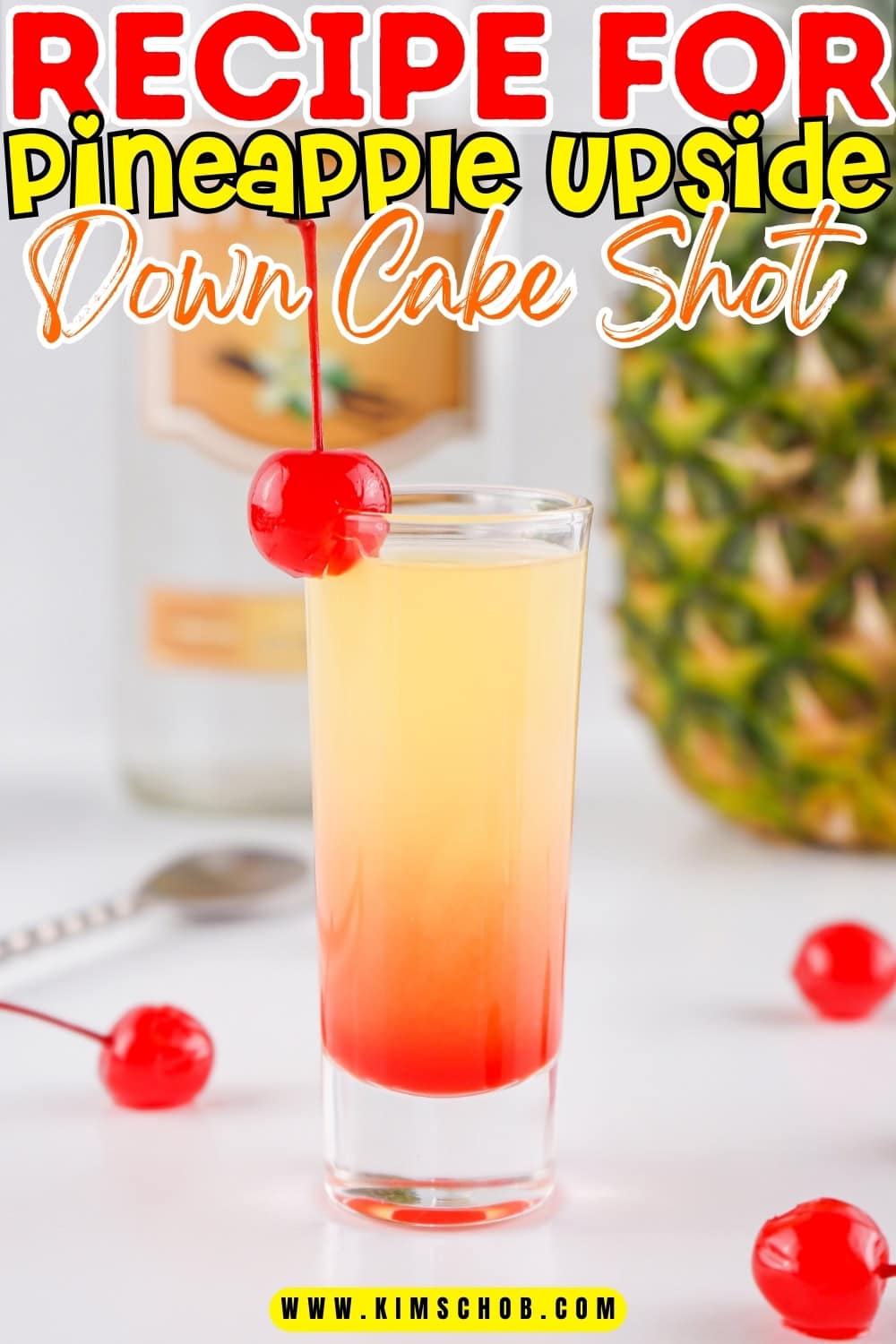 A shot glass with pineapple vodka garnished with cherry.