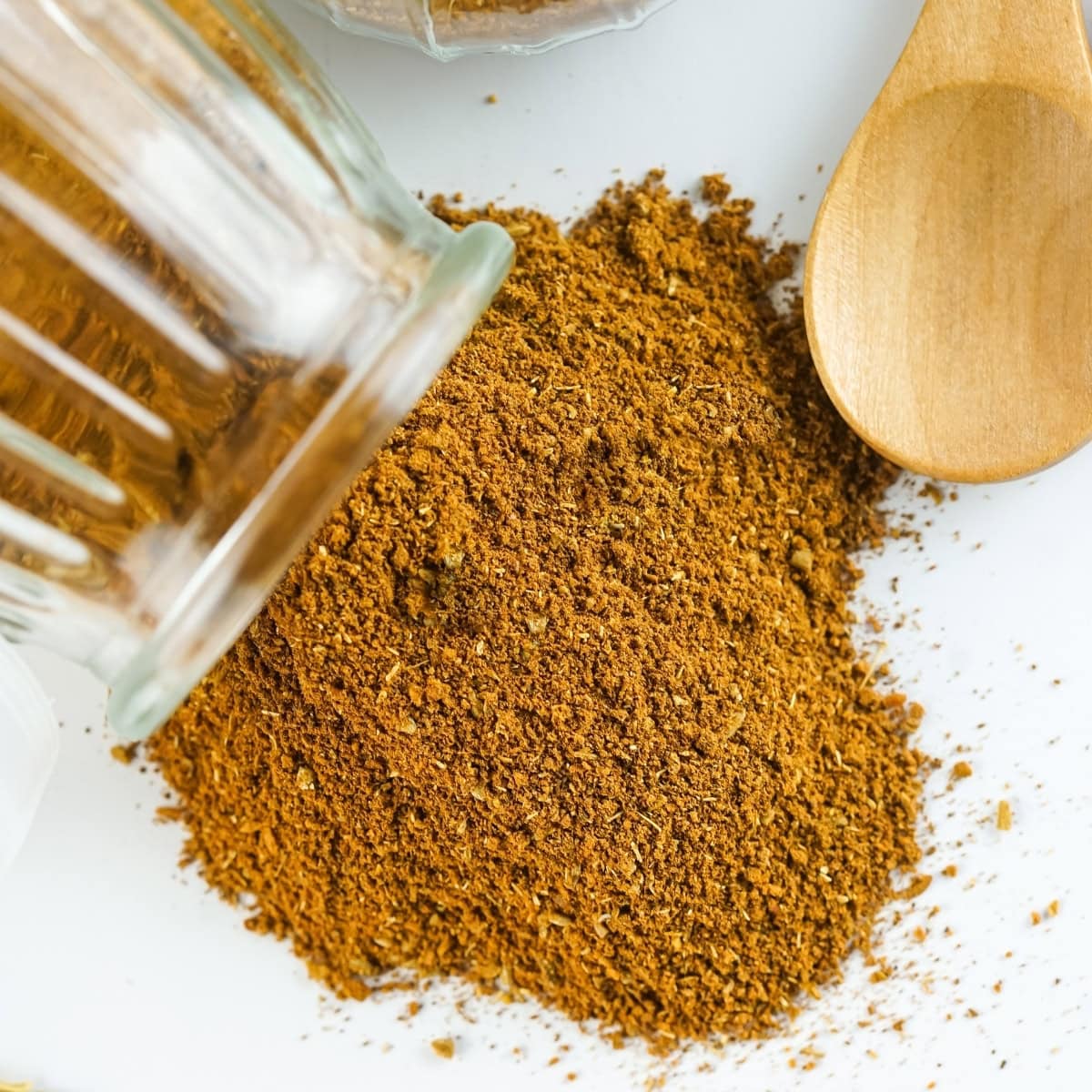 Chinese 5 Spice Powder in a glass container spilled on a countertop.