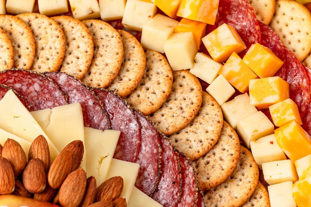 Charcuterie board with a variety of meats, cheeses, and crackers.