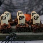 Brownies are decorated as graveyards on wooden boards, with spider decorations on the sides.