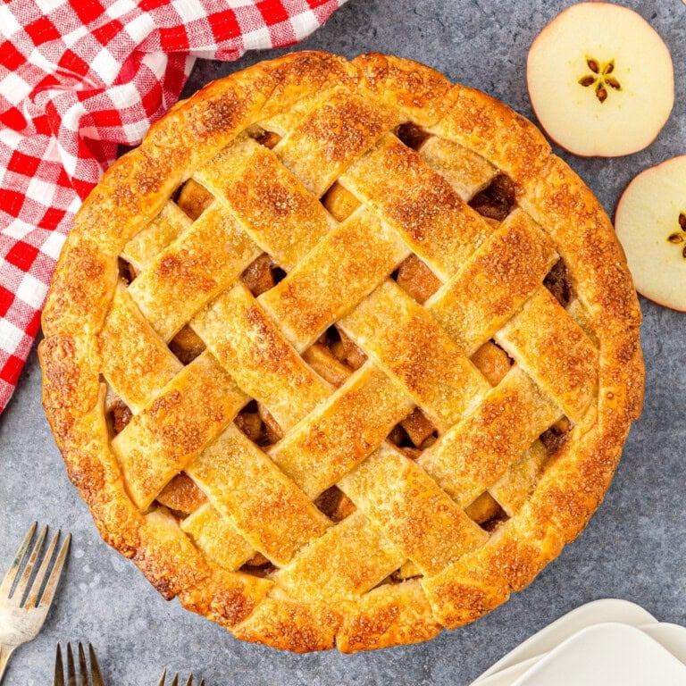 A freshly baked lattice apple pie on a table.