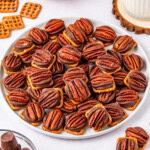 Plate of pretzels topped with rolos and pecans.