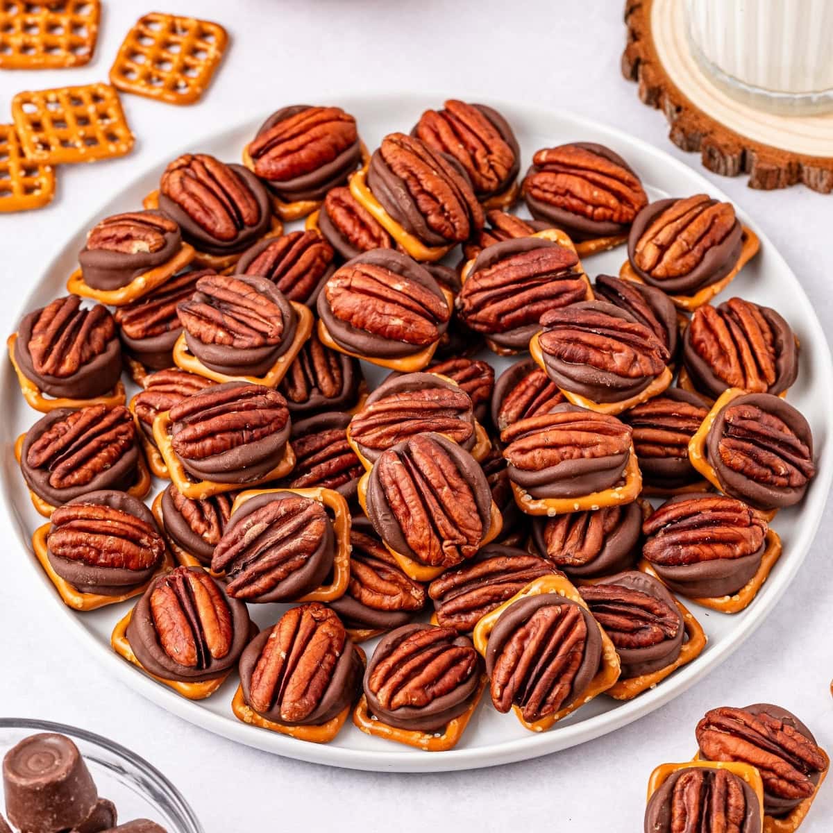 Plate of pretzels topped with rolos and pecans.