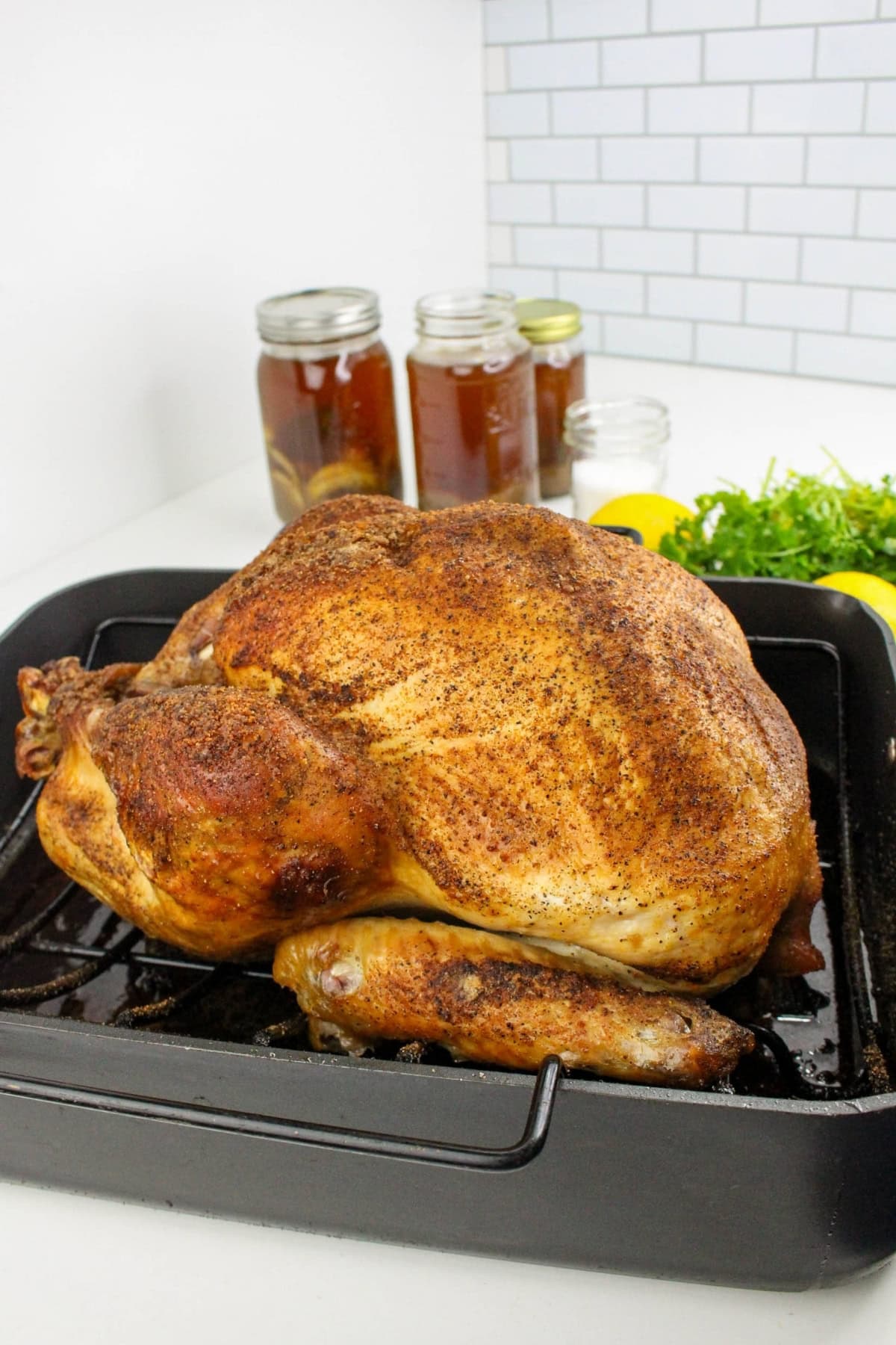 Roasted turkey in a pan with herbs.