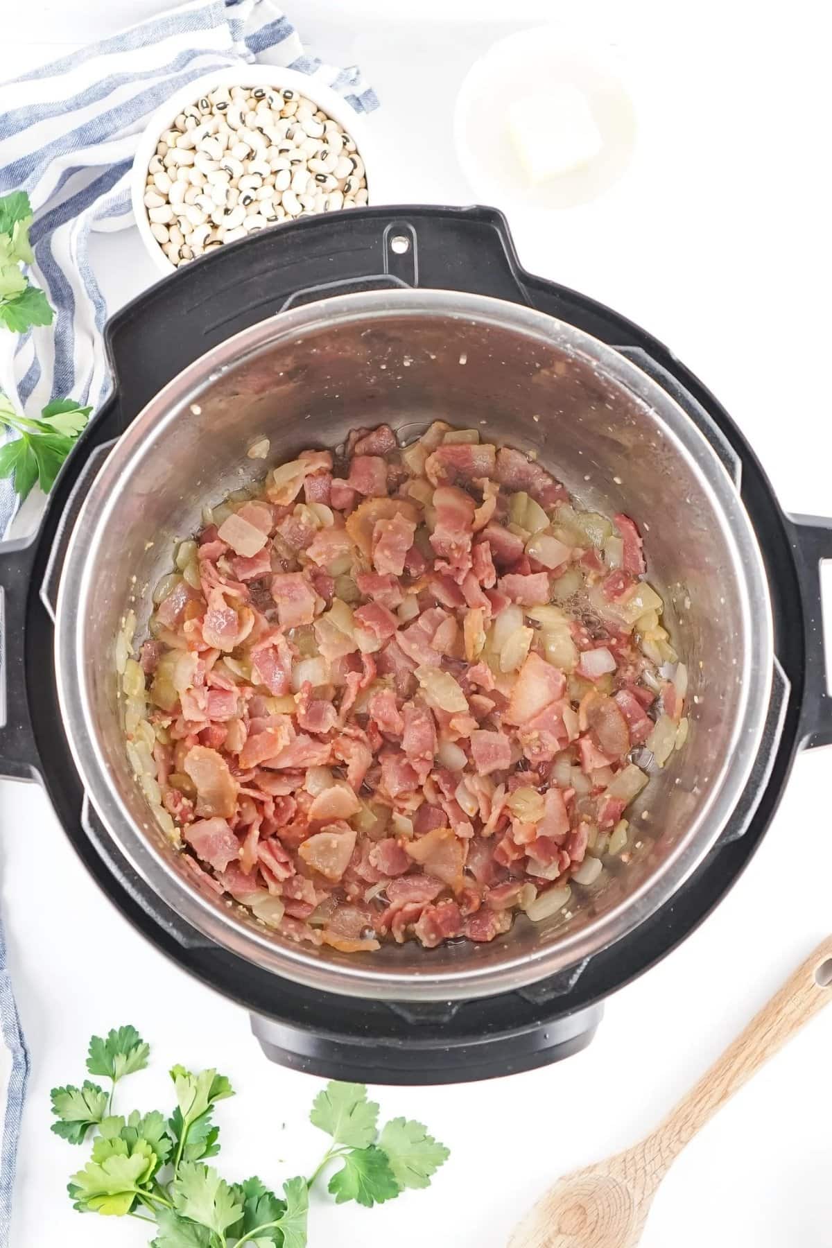 Bacon and onions cooking in an Instant Pot.