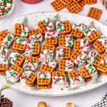 Plate of pretzel bites with white frosting and festive sprinkles.