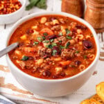 Bowl of pasta soup with beans, meat, and vegetables.