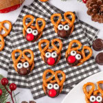 Reindeer-shaped treats with pretzels, chocolate, and candies on a checkered napkin.