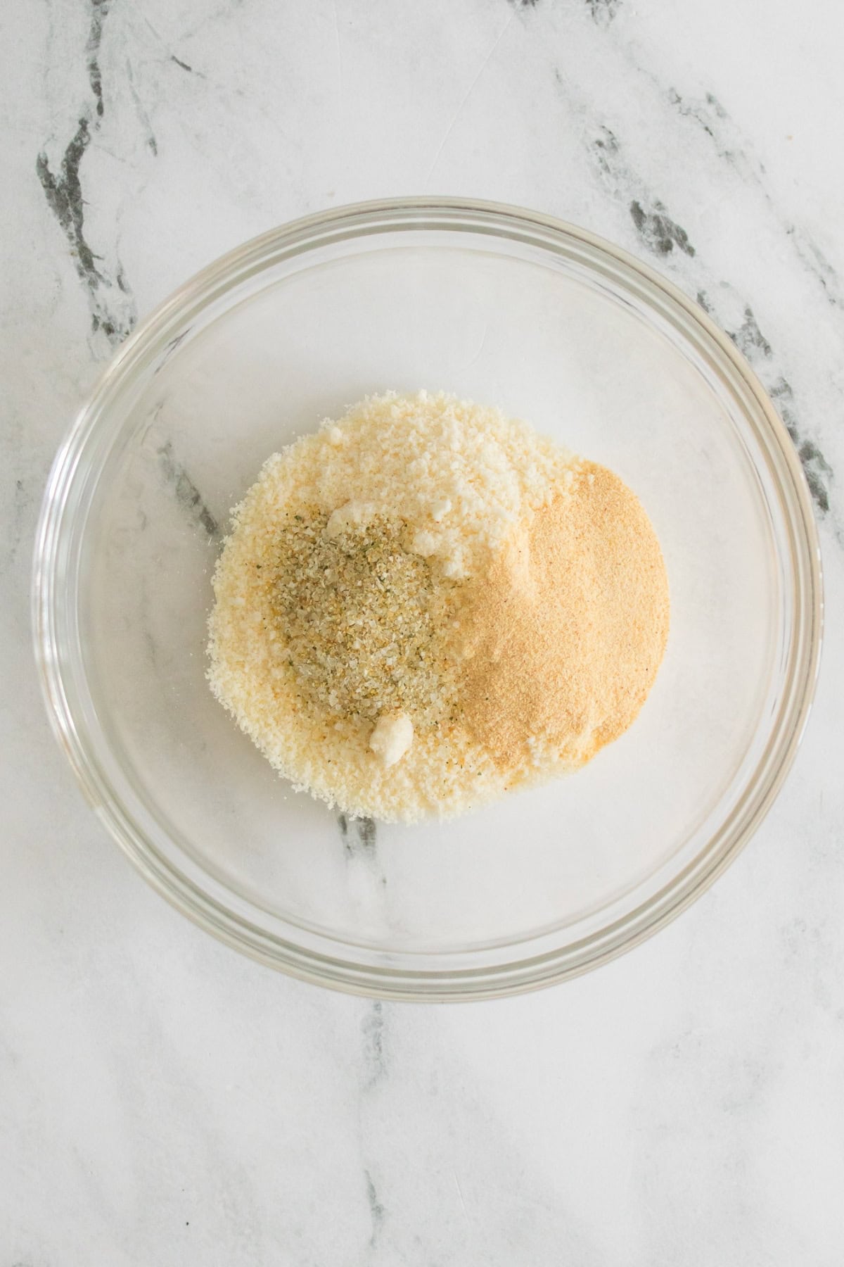 Clear bowl with a mix of breadcrumbs and seasoning.