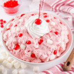 A bowl of Fireball Cherry Fluff salad with cherries, marshmallows, and whipped cream.