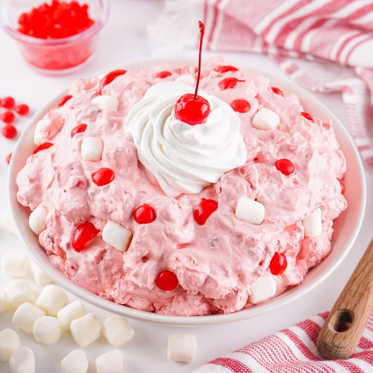 A bowl of Fireball Cherry Fluff salad with cherries, marshmallows, and whipped cream.