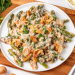 Green bean casserole topped with crispy onions on a white plate.