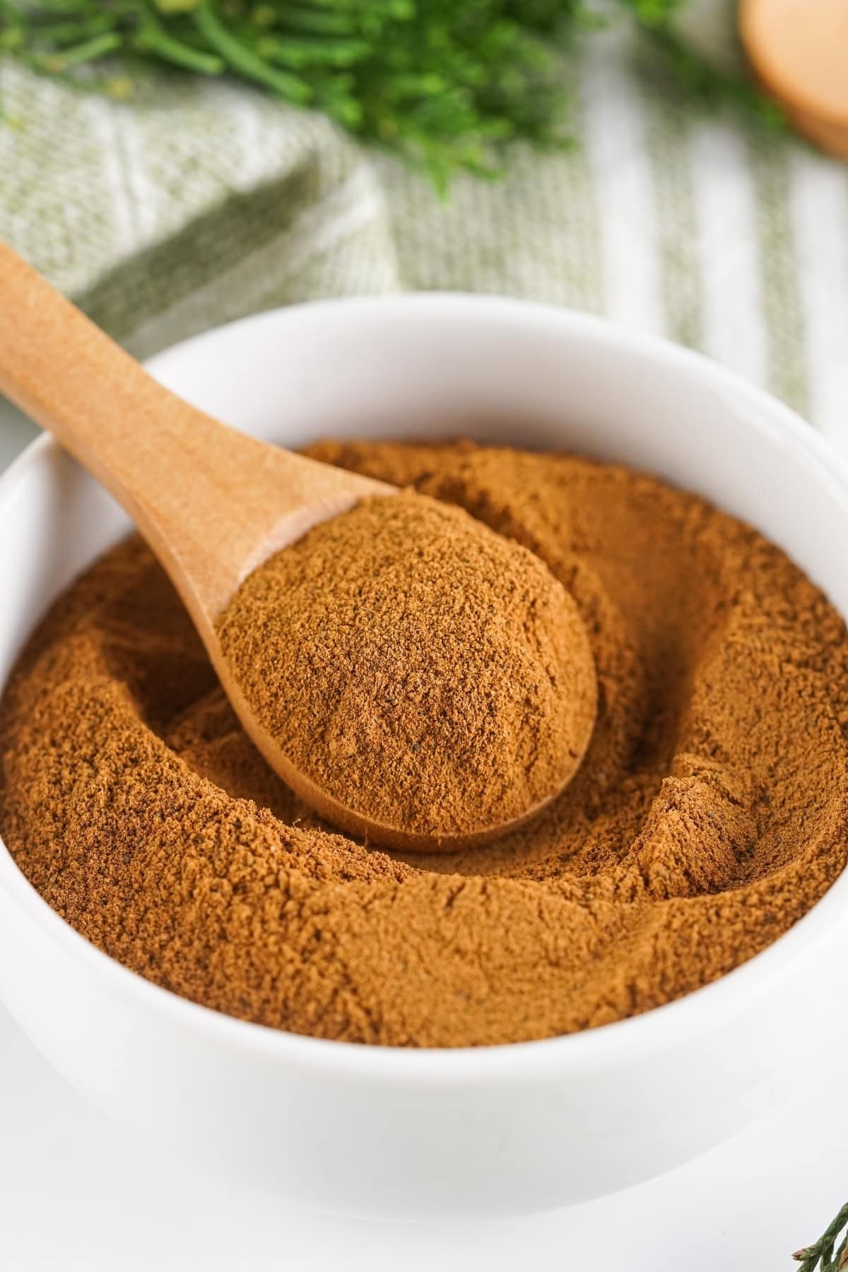 Bowl of spice blend with a wooden spoon on top.
