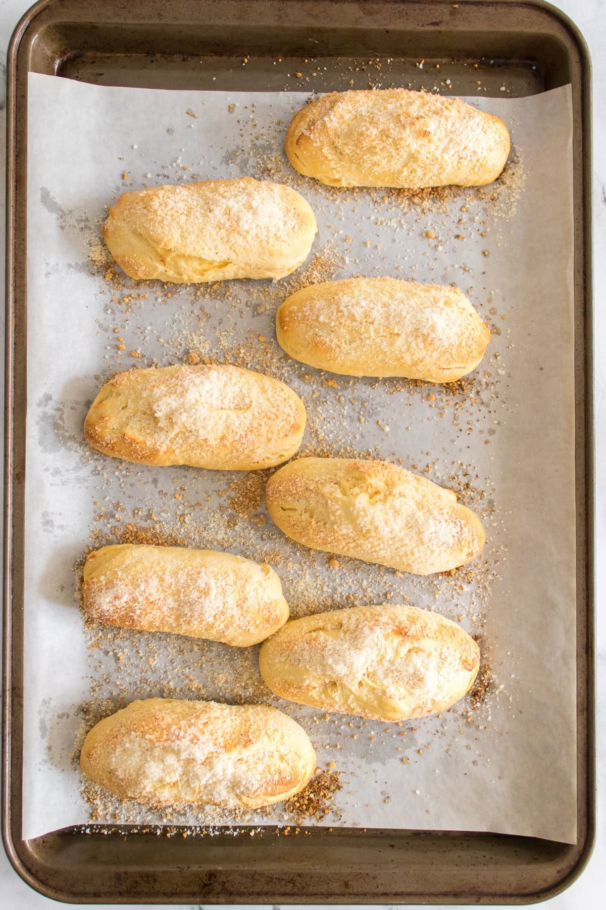 Eight freshly baked pastries on a parchment-lined baking sheet.