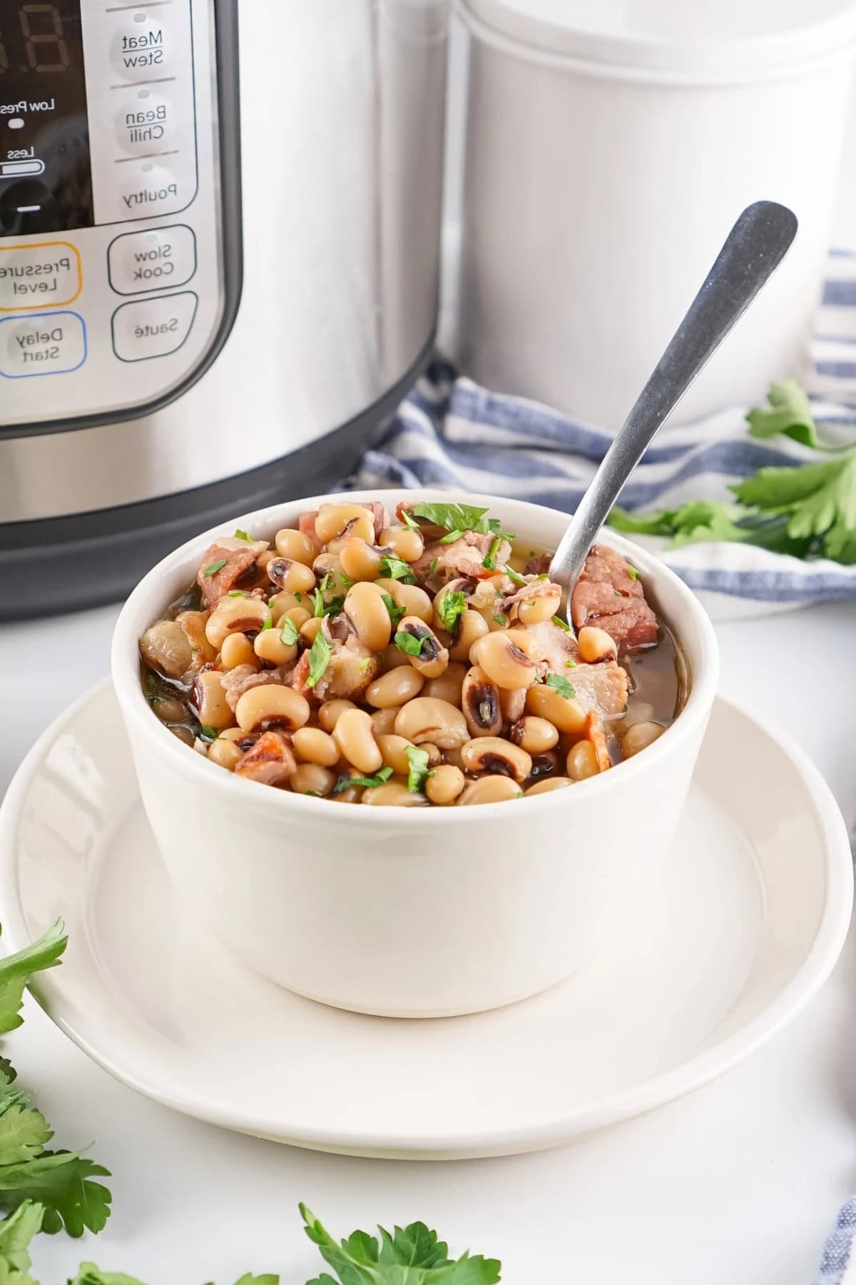 Bowl of beans with herbs and bacon.