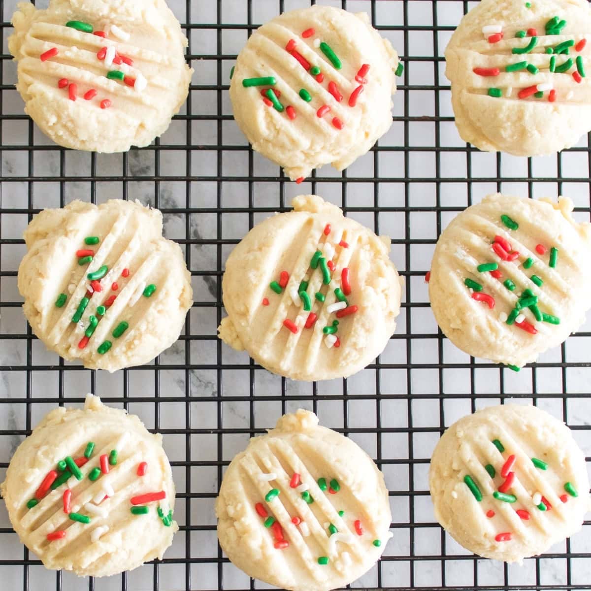 Cookies with colorful sprinkles on a cooling rack.