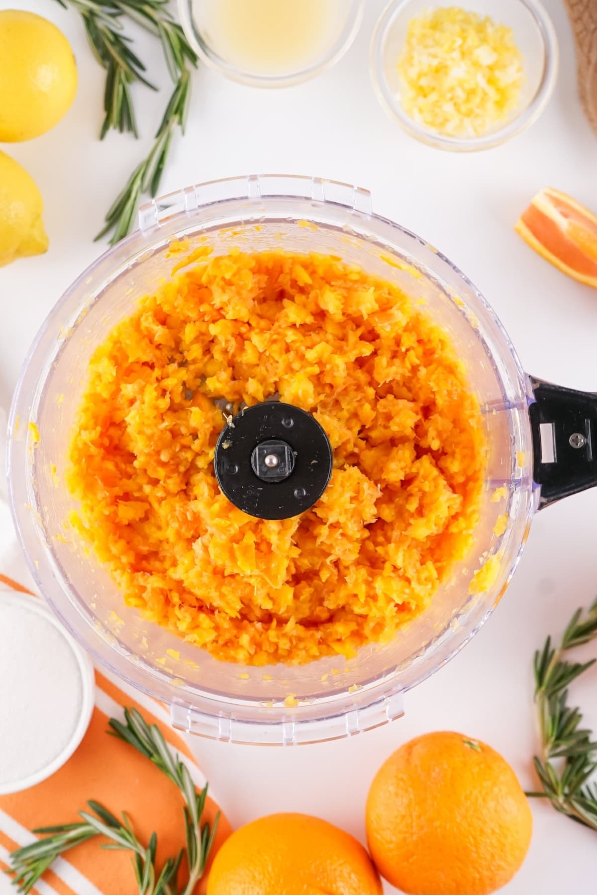 Food processor with chopped orange mixture.