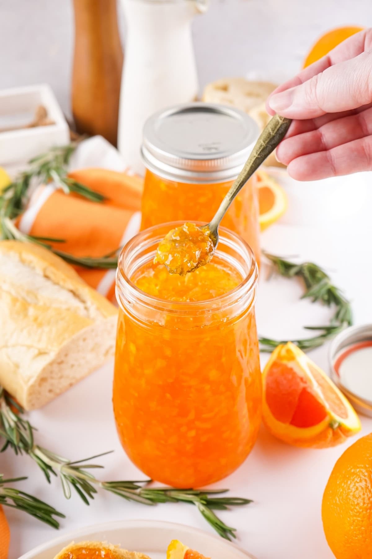 A jar of orange marmalade with a spoon.