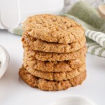 Stack of five almond butter cookies on a white surface.