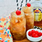 Two slushies with cherries and straws.