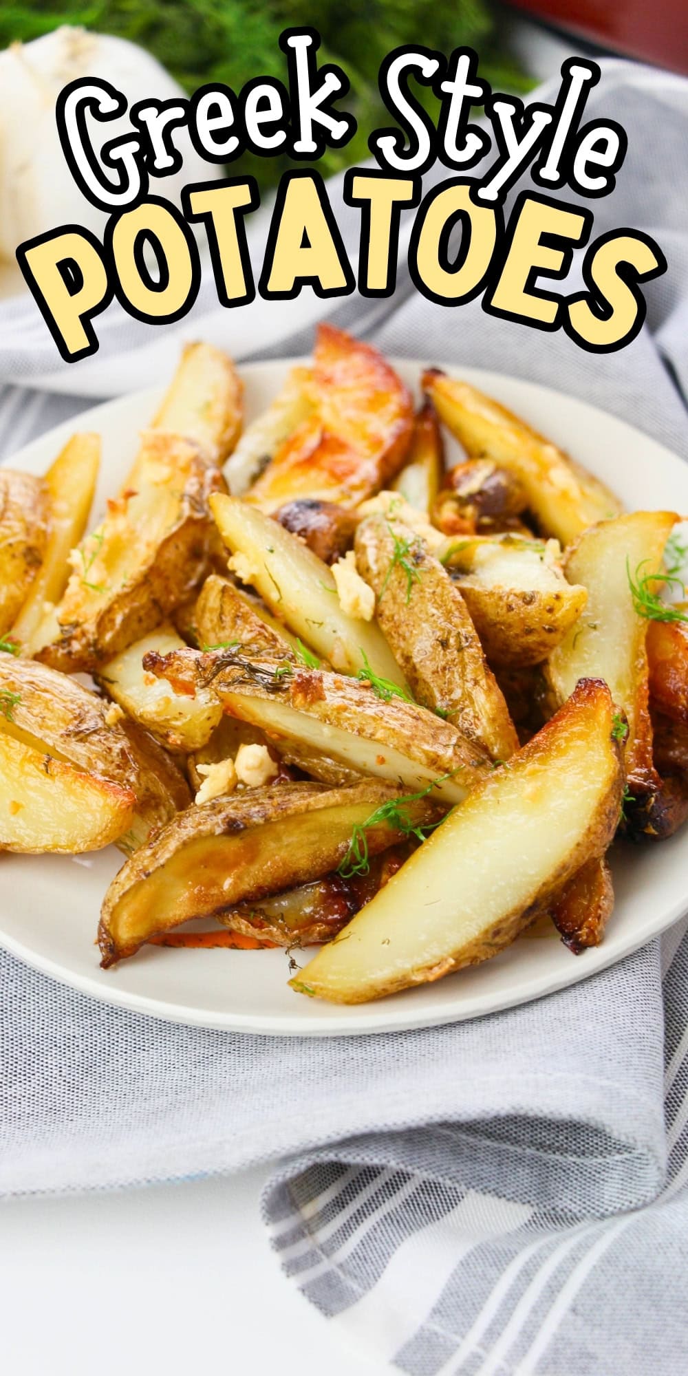 Plate of Greek-style roasted potatoes with herbs, on a cloth napkin.