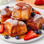 French toast cubes with strawberries, blueberries, and powdered sugar.