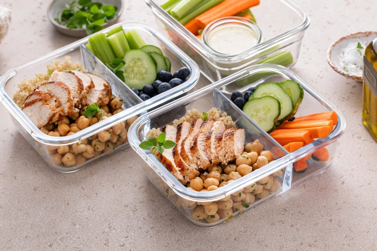 Meal prep containers with grilled chicken, chickpeas, quinoa, and veggies.