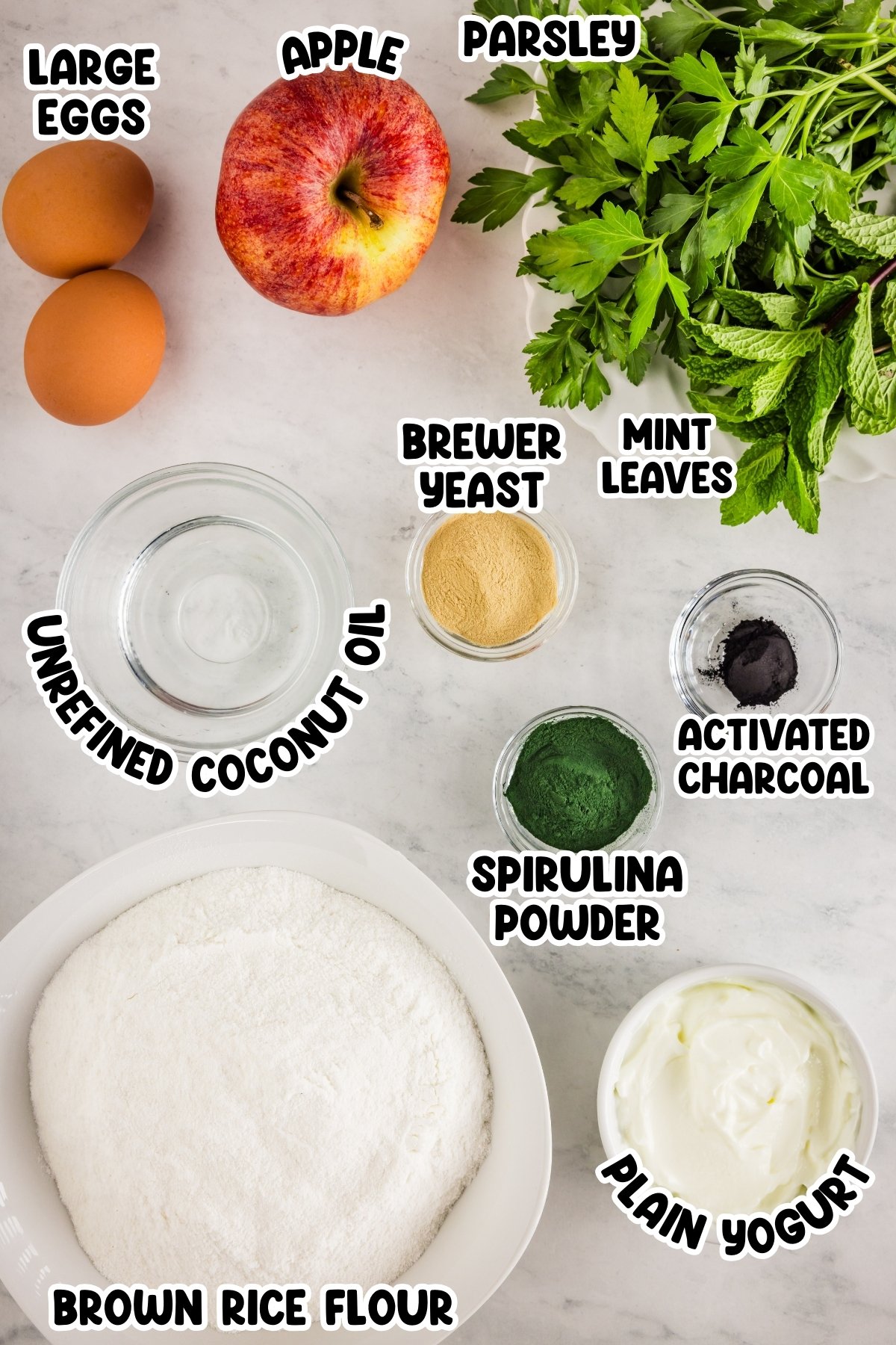 Ingredients for a recipe, labeled eggs, apple, parsley, mint, flour, and powders.