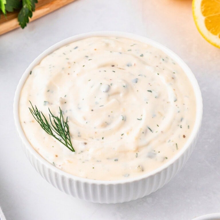 Simple homemade tartar sauce with herbs, served in a white bowl and fresh dill.