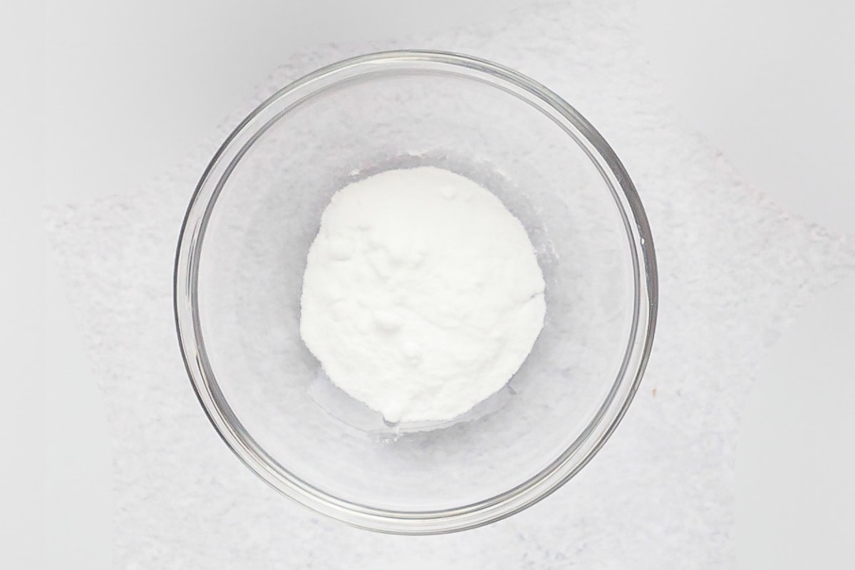 A glass bowl filled with baking soda.