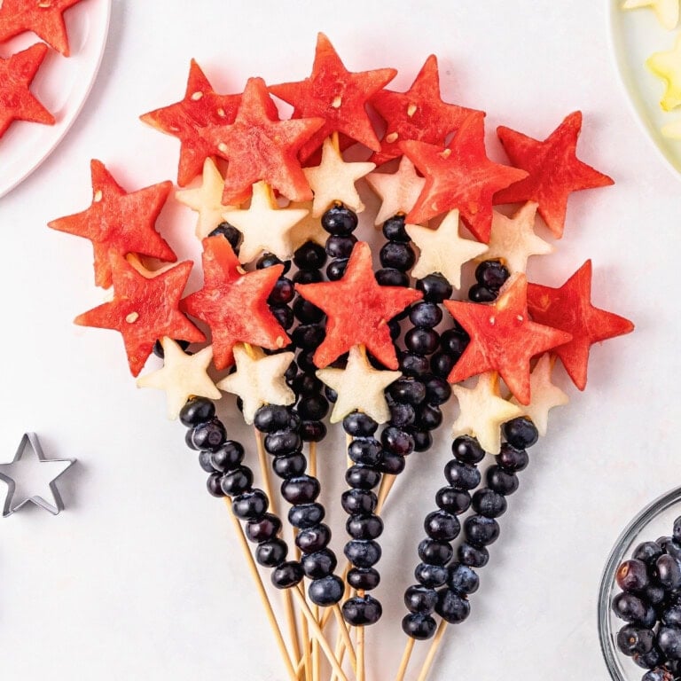 Watermelon skewers and blueberries arranged like a star-shaped fruit bouquet.