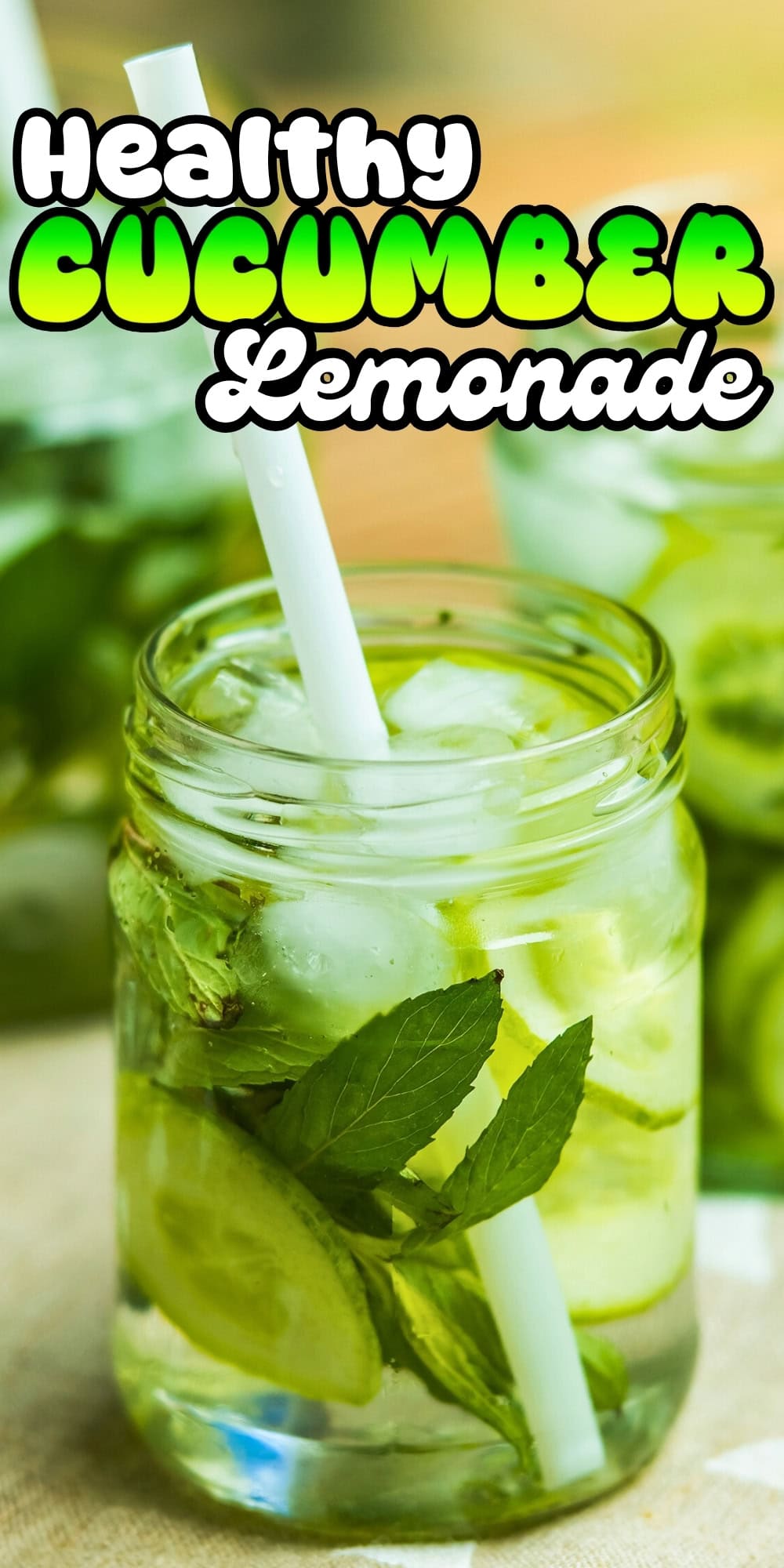A jar of cucumber lemonade with mint leaves, ice, and a straw.