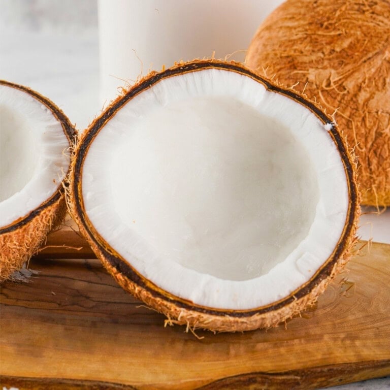A halved coconut shows white flesh—see how to crack open a coconut with ease.