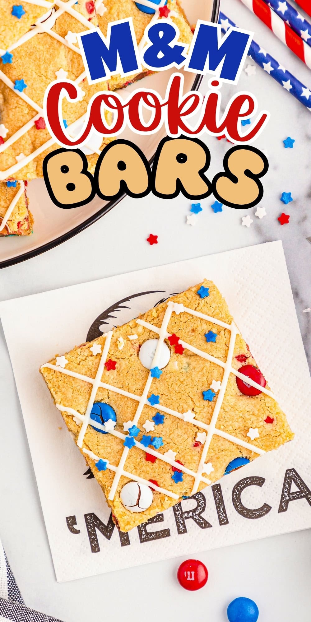 A festive M&M cookie bar on a napkin with red, white, and blue sprinkles.
