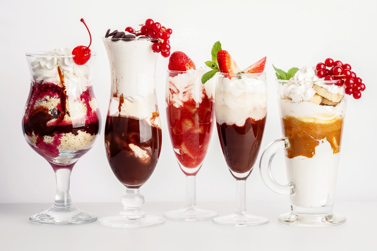 Five no bake summer desserts: Ice cream sundaes with fruit and whipped cream.