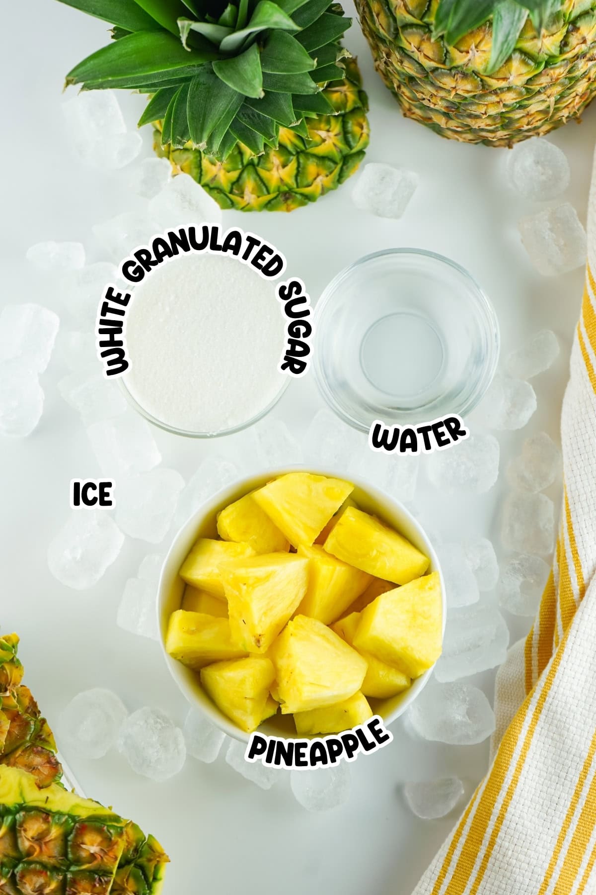 Bowl of pineapple, sugar, water, and ice on a white surface with pineapples.
