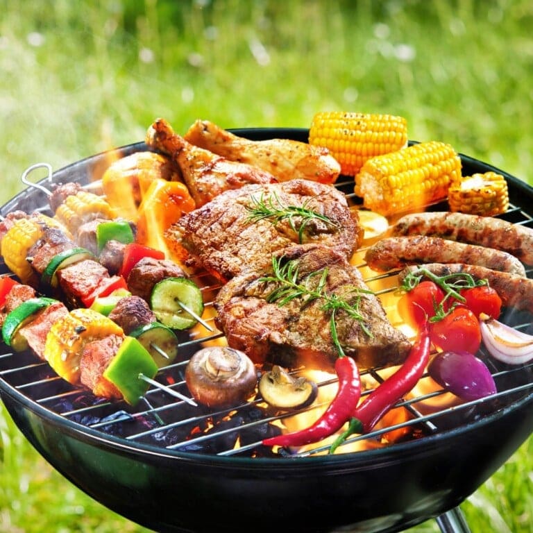 Assorted meats and veggies grilling outdoors with essential grill safety tips.