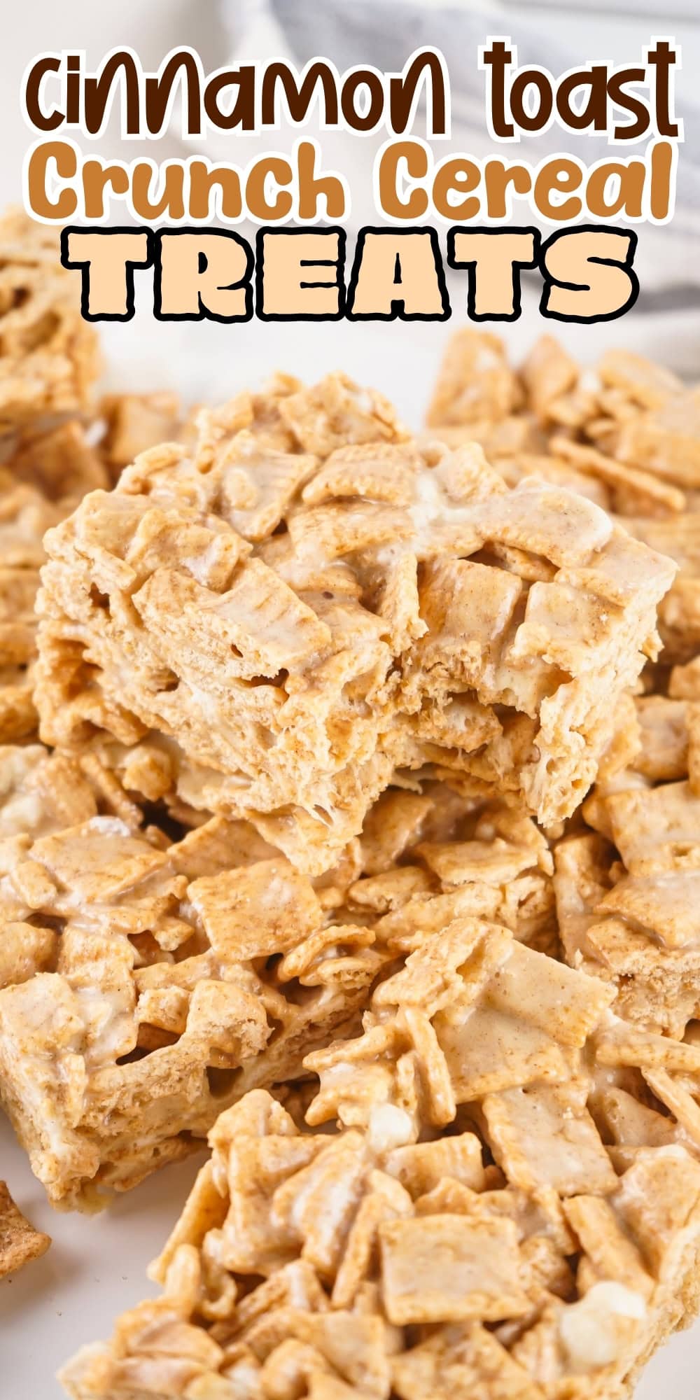 Cinnamon Toast Crunch cereal treats stacked on a white surface.